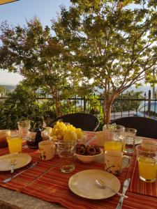 einen Tisch mit Teller und Gläsern Orangensaft in der Unterkunft Apartments Bobinac in Senj