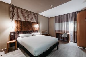 una camera d'albergo con un letto grande e una scrivania di Ibis Mohammedia a Mohammedia
