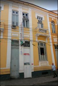 un hombre está parado frente a un edificio en Hotel Cabo Finisterra, en Río de Janeiro