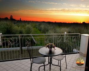 un tavolo e sedie su un balcone con vista sul tramonto di La Chianarella ad Ascea