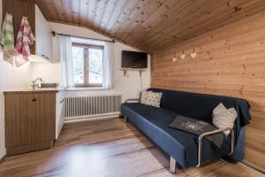 a living room with a blue couch and a kitchen at Apartment Haus Gold in Fusch an der Glocknerstraße