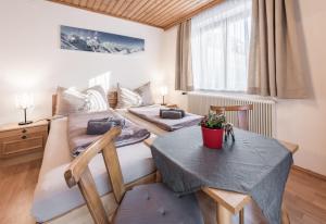 a hotel room with two beds and a table at Apartment Haus Gold in Fusch an der Glocknerstraße
