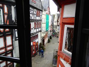 2 personnes marchant dans une rue avec des bâtiments dans l'établissement Gasthaus Burgkeller, à Limburg an der Lahn