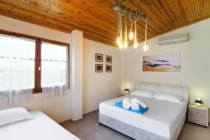 two beds in a bedroom with a wooden ceiling at Villa Hara in Nea Irakleia