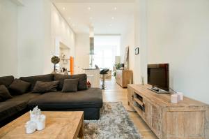 a living room with a couch and a flat screen tv at Apartment Pacific - Duplex with Sauna in Antwerp