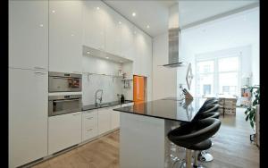 a kitchen with white cabinets and a black counter top at Apartment Pacific - Duplex with Sauna in Antwerp