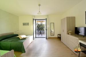 una camera con letto, televisore e tavolo di La Chianarella ad Ascea