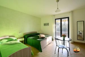 una camera da letto con due letti, un tavolo e una finestra di La Chianarella ad Ascea