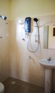 ein Bad mit einer Dusche und einem Waschbecken in der Unterkunft Family Lodge 25 in Kota Bharu