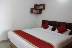 ein Schlafzimmer mit einem großen Bett mit roten Kissen in der Unterkunft Sam's Terrace in Chikmagalur