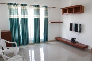 ein Wohnzimmer mit einem Stuhl und einem Fenster in der Unterkunft Sam's Terrace in Chikmagalur