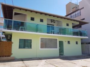 una casa con un balcón de cristal encima en Pousada Floripamar I, en Florianópolis