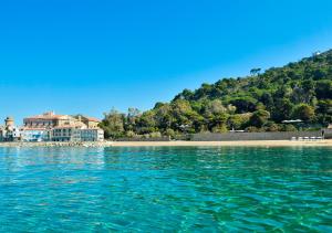 vistas a una playa con una casa en el agua en Palazzo Belmonte, en Santa Maria di Castellabate