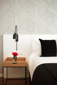 a bedroom with a bed and a table with a vase of flowers at CasaSur Palermo Hotel in Buenos Aires