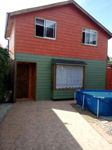 een rood en groen huis met een garage bij Cabañas Emma in Osorno