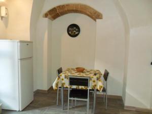 a kitchen with a table with chairs and a clock on the wall at resort san paolo in Modica