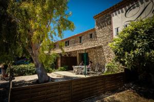 une femme assise à une table devant une maison dans l'établissement Les Fenals, à Fitou