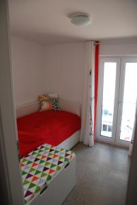 a bedroom with a red bed and a sliding glass door at Remise am Schlosspark in Schwielowsee