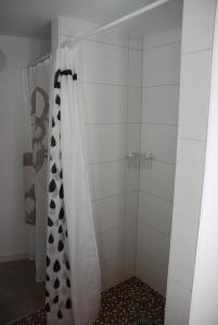 una ducha con cortina de ducha en blanco y negro en Remise am Schlosspark, en Schwielowsee