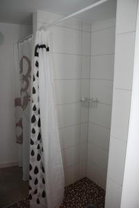 a shower with a black and white shower curtain at Remise am Schlosspark in Schwielowsee