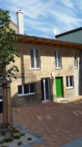 a brick building with a green door on it at Remise am Schlosspark in Schwielowsee