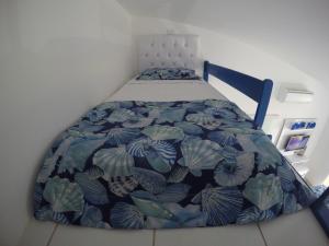 a bed with a blue and white comforter on it at Village Galés Maragogi - Chalé 03 in Maragogi +31 photos