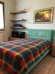 - une chambre avec un lit et une couverture colorée dans l'établissement Edolo centro, à Edolo