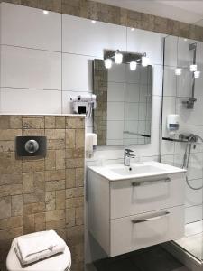 a bathroom with a sink and a toilet and a mirror at Hotel Riviera in Bastia