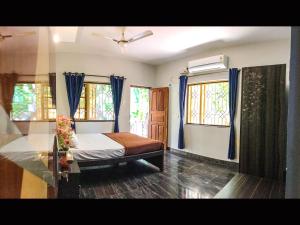 a bedroom with a bed and two windows at Palolem Apartments in Palolem