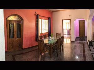 a dining room with a wooden table and chairs at Palolem Apartments in Palolem