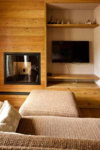 a living room with a fireplace and a tv at Elegante attico sulle piste di Pila in Pila