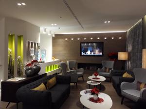 a living room with couches and a flat screen tv at Hotel Soperga in Milan