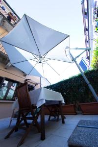 a table and chairs with an umbrella on a patio at B&B Terrazza Baires - in the heart of Milan in Milan