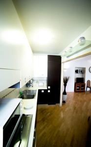 a kitchen with white cabinets and a wooden floor at B&B Terrazza Baires - in the heart of Milan in Milan