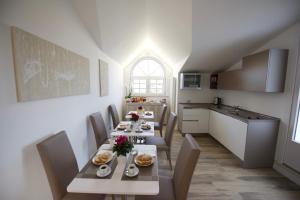 a dining room with a table and chairs and a kitchen at Domus Dams B&B in Montescaglioso