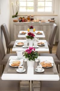 Domus Dams B&B في مونتيسكاليوزو: طاولة طويلة عليها أطباق من الطعام والزهور