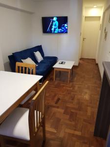 sala de estar con sofá azul y mesa en Apartamento Carlucci en Córdoba