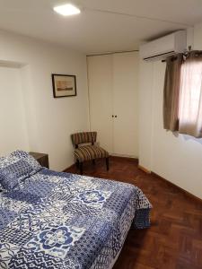 1 dormitorio con 1 cama y 1 silla en Apartamento Carlucci en Córdoba