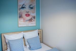 łóżko z dwoma poduszkami i obrazem na ścianie w obiekcie Apartament Widokówka w mieście Gdynia