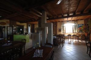 a dining room with tables and chairs and a large window at Valli Unite in Costa Vescovato +41 photos