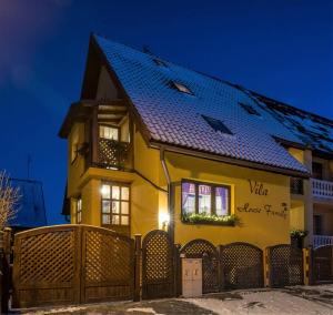 ein gelbes Haus mit blauem Dach in der Unterkunft Vila House Family in Poprad