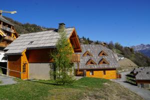 una casa de madera con techo en una colina en Hameau Pra Roustan by Godille, en Pra-Loup