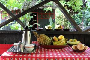 a table with a bowl of fruit on a red table cloth at Maloka Napü - Ecodestinos in Puerto Nariño