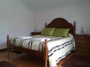 Un dormitorio con una cama con almohadas verdes. en Maison Blanche en Guizande