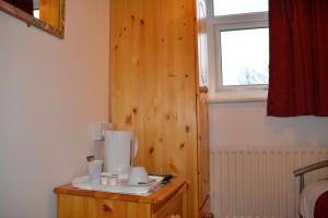 Habitación con pared de madera y ventana. en Bow Guest House, en Reading