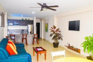 a living room with a blue couch and a kitchen at Blue Ocean Apartments Chipipe in Salinas