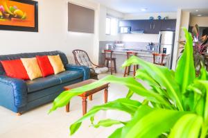 a living room with a couch and a kitchen at Blue Ocean Apartments Chipipe in Salinas