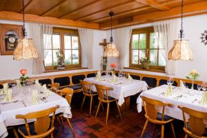 Hotel Gasthof zum Rössle في ألتينشتاد: غرفة طعام مع طاولات بيضاء وكراسي ونوافذ