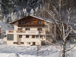 un edificio nella neve vicino a un albero di Lechlihof a Ischgl