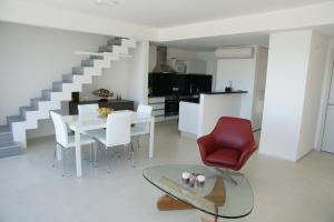 een woonkamer met een witte tafel en een rode stoel bij Rinconada del Mar in Punta del Este